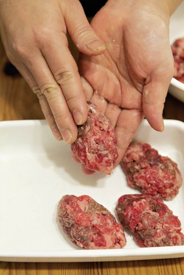 牛肉に調味料と粉を振って、ぎゅっと握ってラグビーボール状に形作る。ほどけないよう、しっかり握るのがコツ