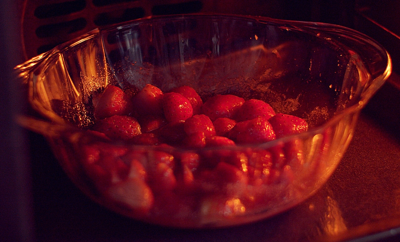 写真：よく混ぜた耐熱容器に入ったいちごを、容器ごとオーブンに入れ焼いている様子