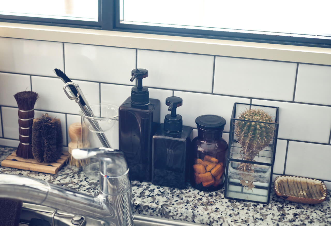 食洗機用タブレット洗剤はガラスの薬瓶に、洗うときに外す調理家電の部品置きには陶器の豆皿をと、シンクまわりも細部までインテリア性を大切にしている。