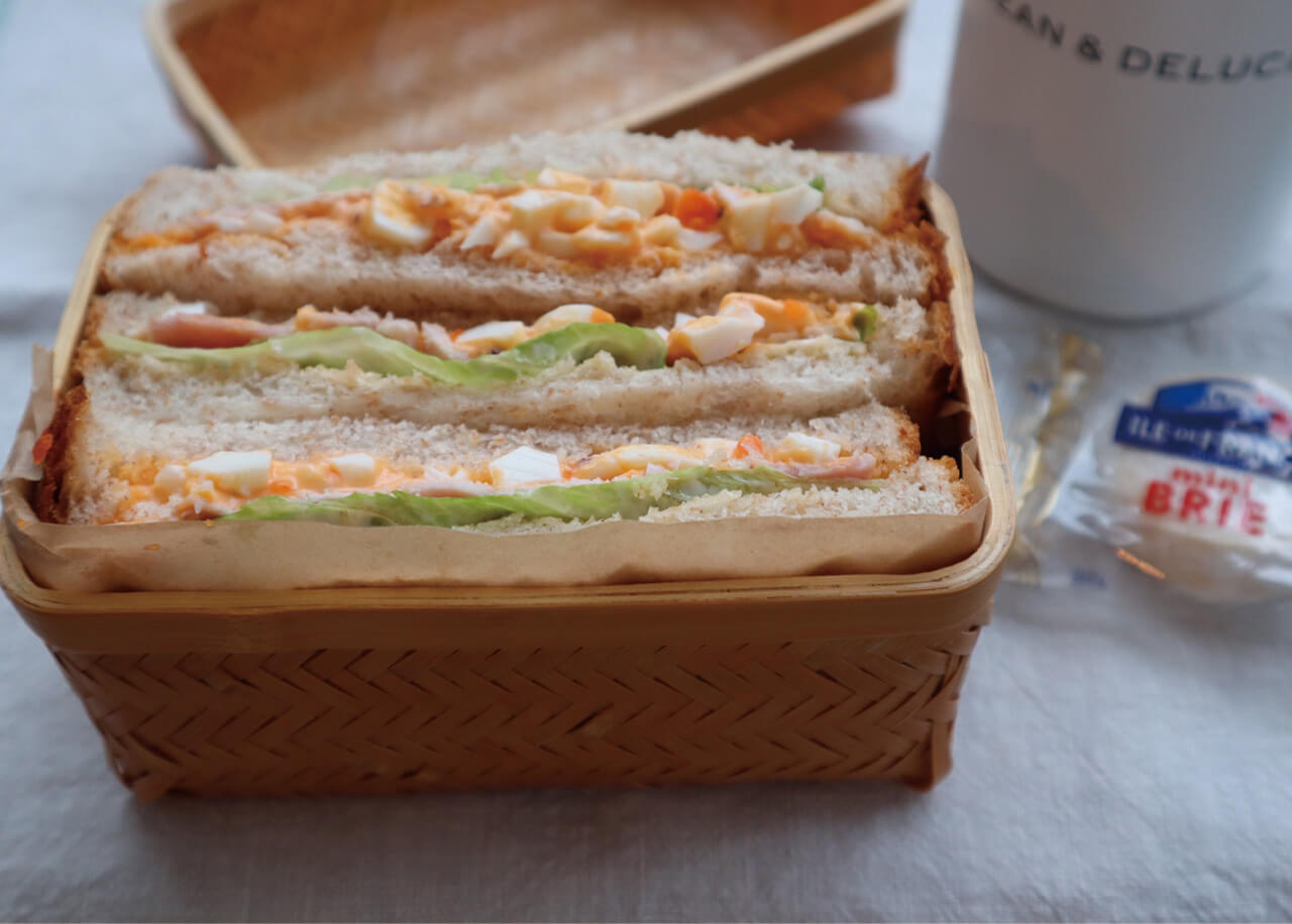 ピクニック気分を味わってほしくて竹かごに入れたサンドイッチ弁当