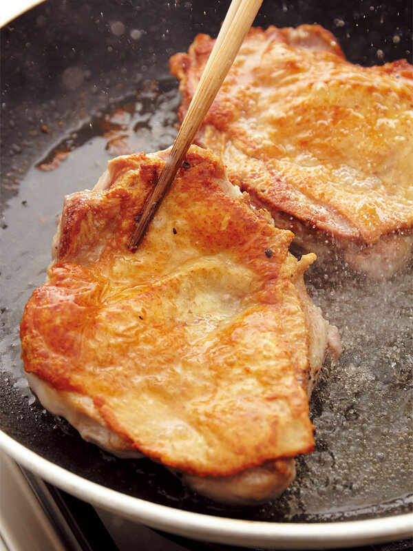 フライパンで鶏肉をソテーする画像：「チキンソテー ミニトマトソース」レシピ／藤井 恵さん