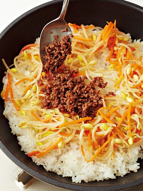 フライパンの上にごはん、野菜を重ね、その上に炒めたひき肉を載せる写真：フライパンひとつで「韓国風焼きビビンバ」レシピ／きじまりゅうたさん