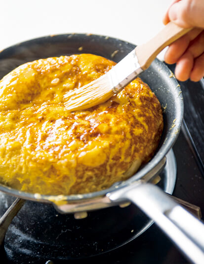 フライパンの中で焼けたオムレツの表面にさらに卵液を塗って焼く画像：「スペイン風オムレツ」レシピ／坂田阿希子さん