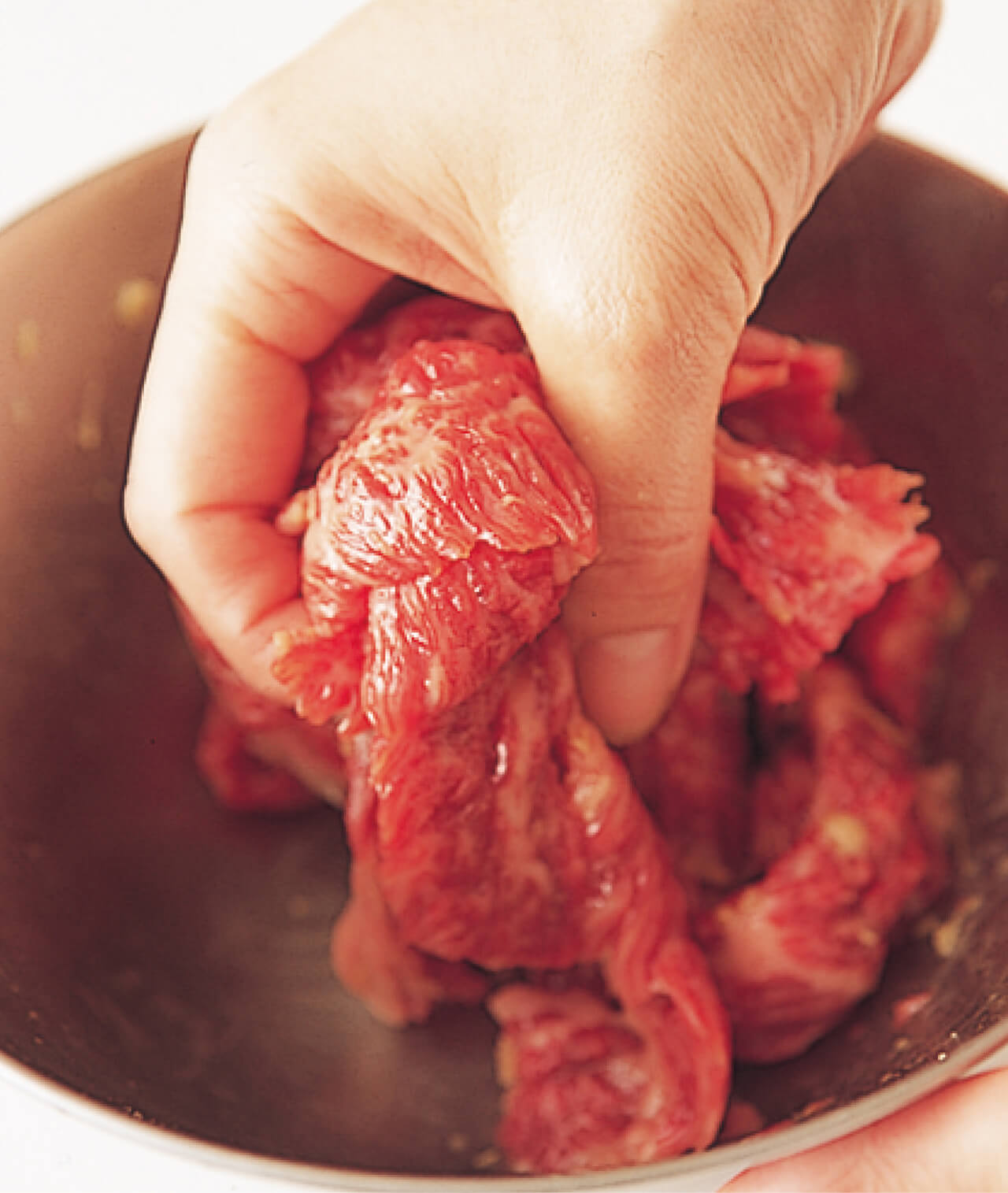 手で牛肉をもむと、調味料がよくしみ込んでおいしさが増す