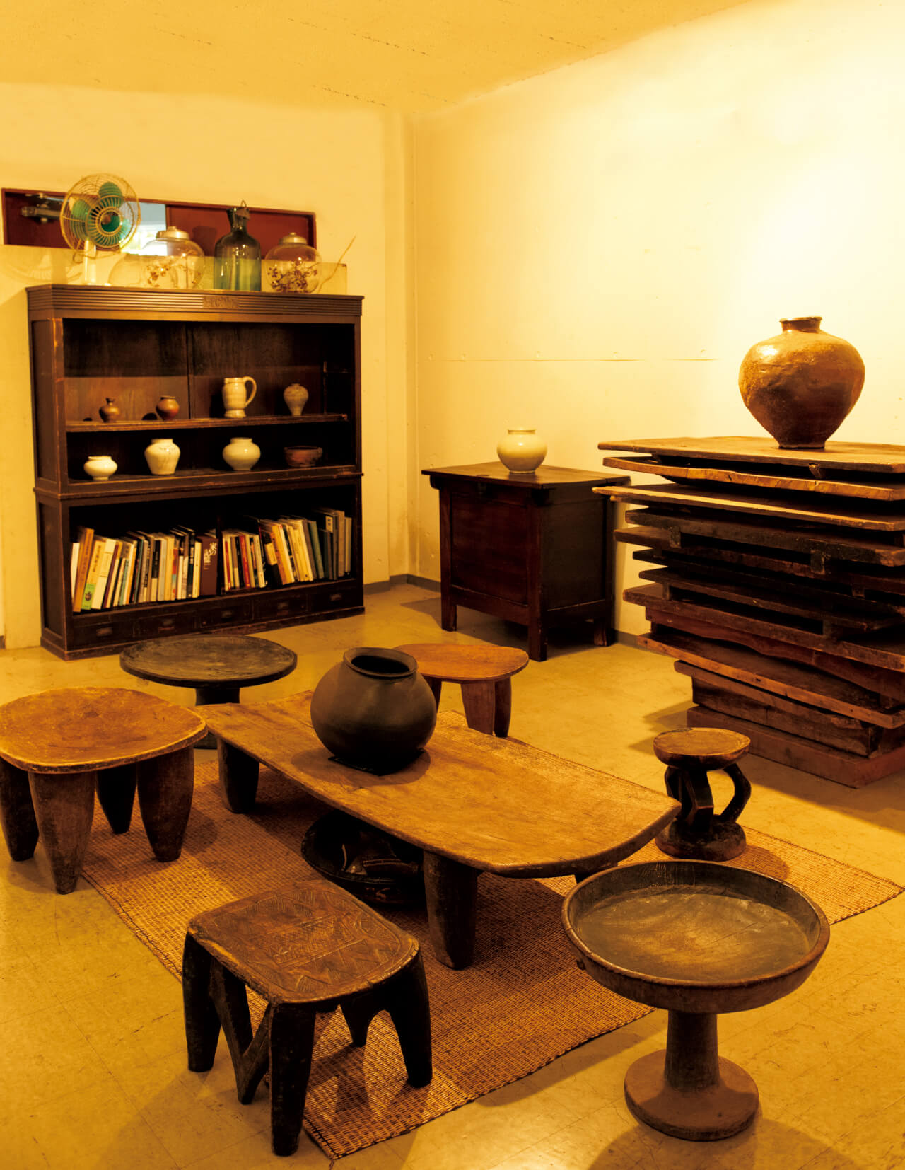 プリミティブなテーブルとイスは、一刀彫のエチオピア製。常滑の大壺、のし板や棚は日本の年代物。