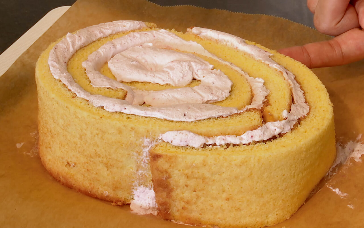 楕円形にスポンジケーキを巻きロールケーキを作る。