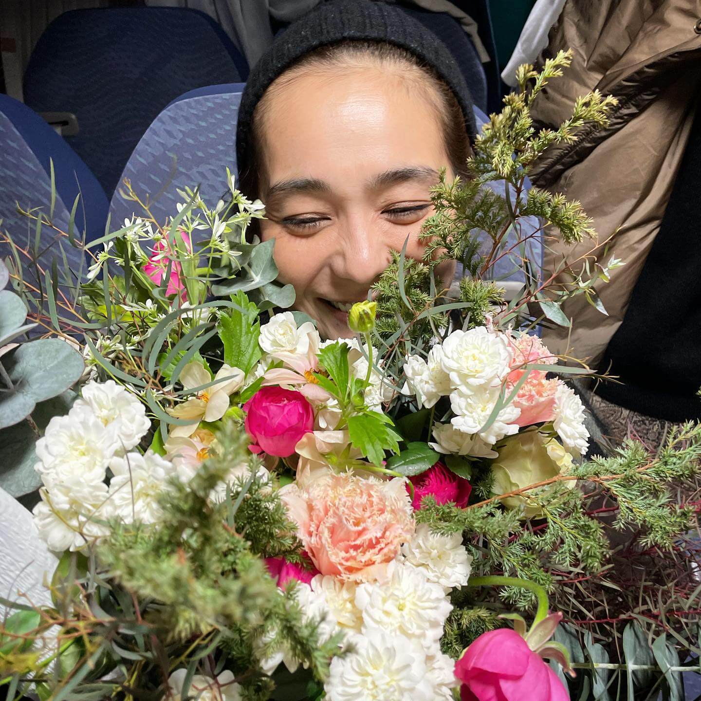 写真：モデル竹下玲奈さんの伏し目がちな笑顔/誕生日サプライズの花束とともに