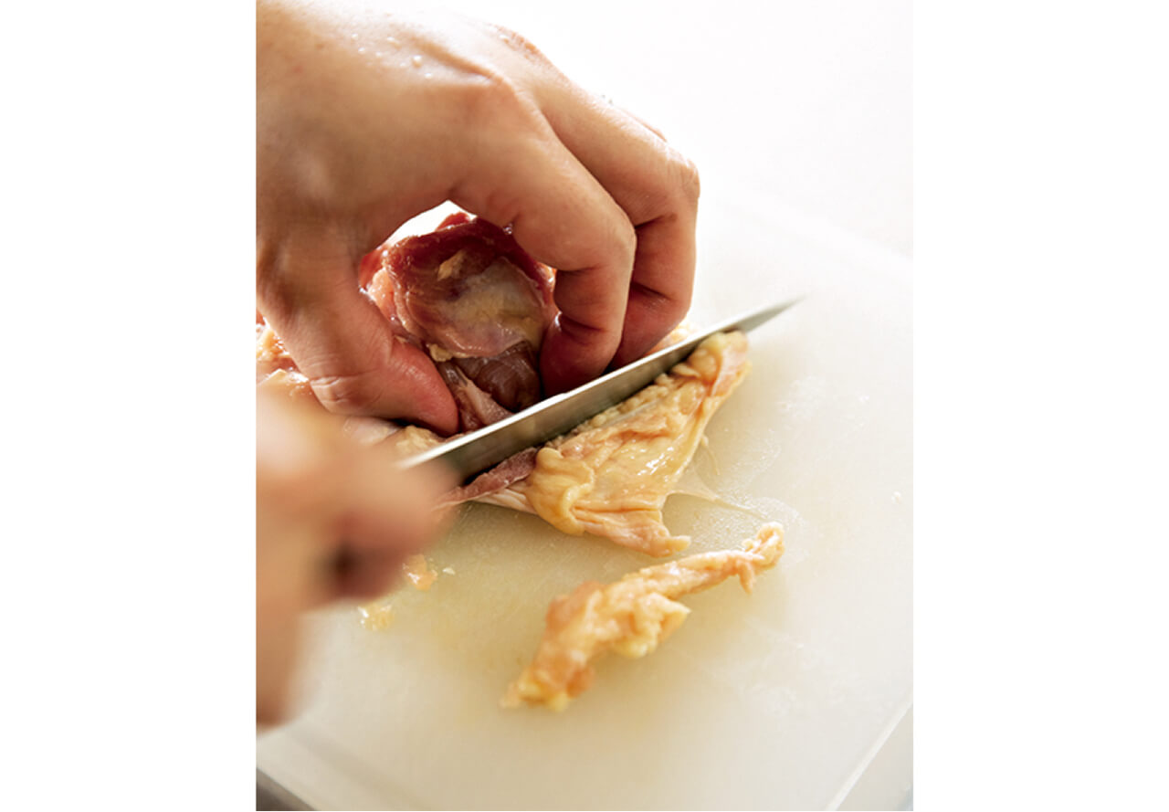 鶏肉の皮と身の間にある余分な脂を除く。皮はうま味が出るので残す。
