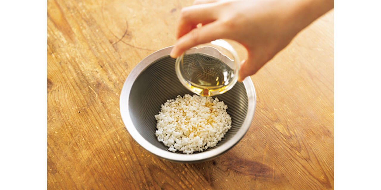 洗った米にごま油をまぶしてまんべんなくコーティングすると、粘りが出なくていい状態で炊ける