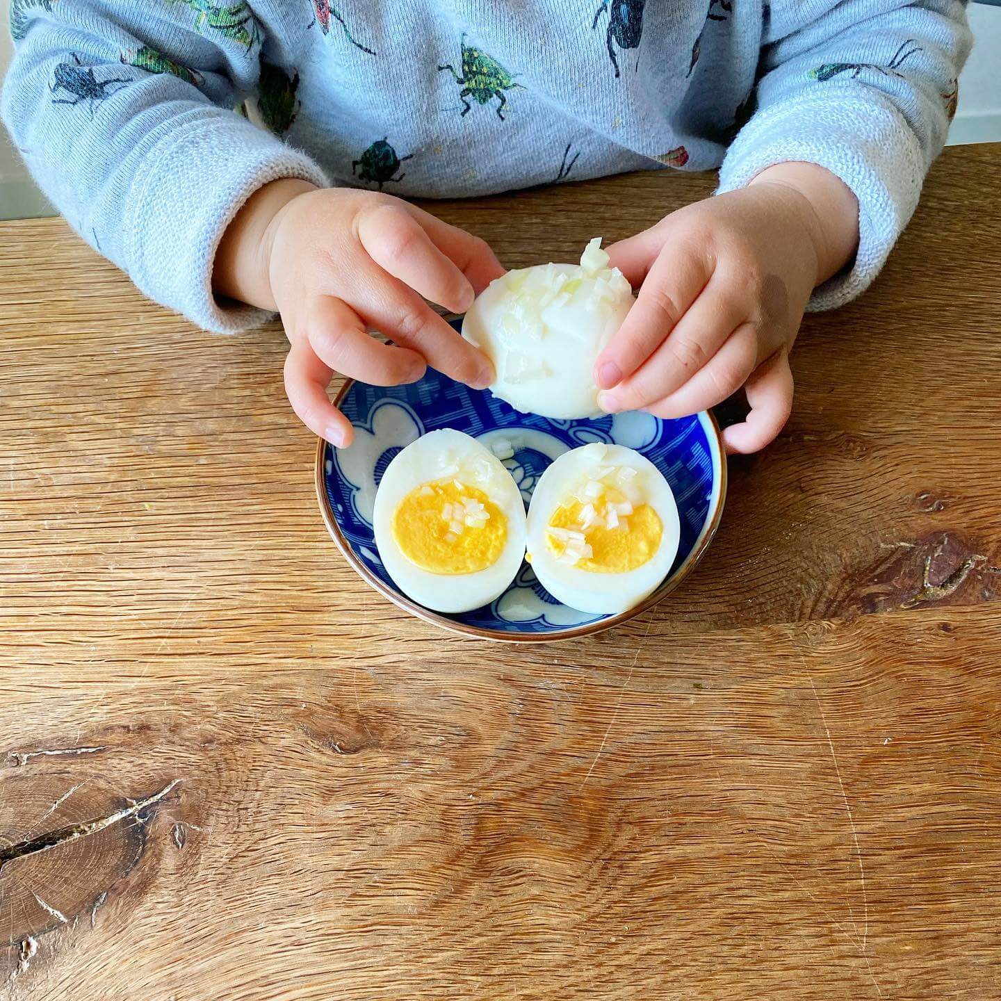 写真：ゆで卵をむく子供の手