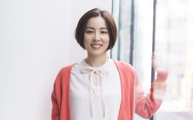 写真：白いブラウスにピンクのカーディガンでほほ笑む綿矢りささん