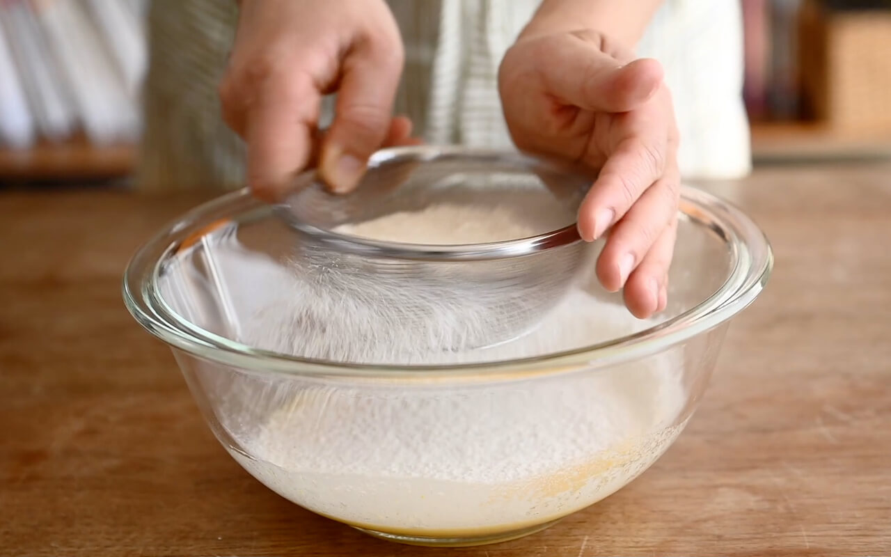 ホットケーキミックスをふるいながら加え、粉が見えなくなるまで混ぜる。