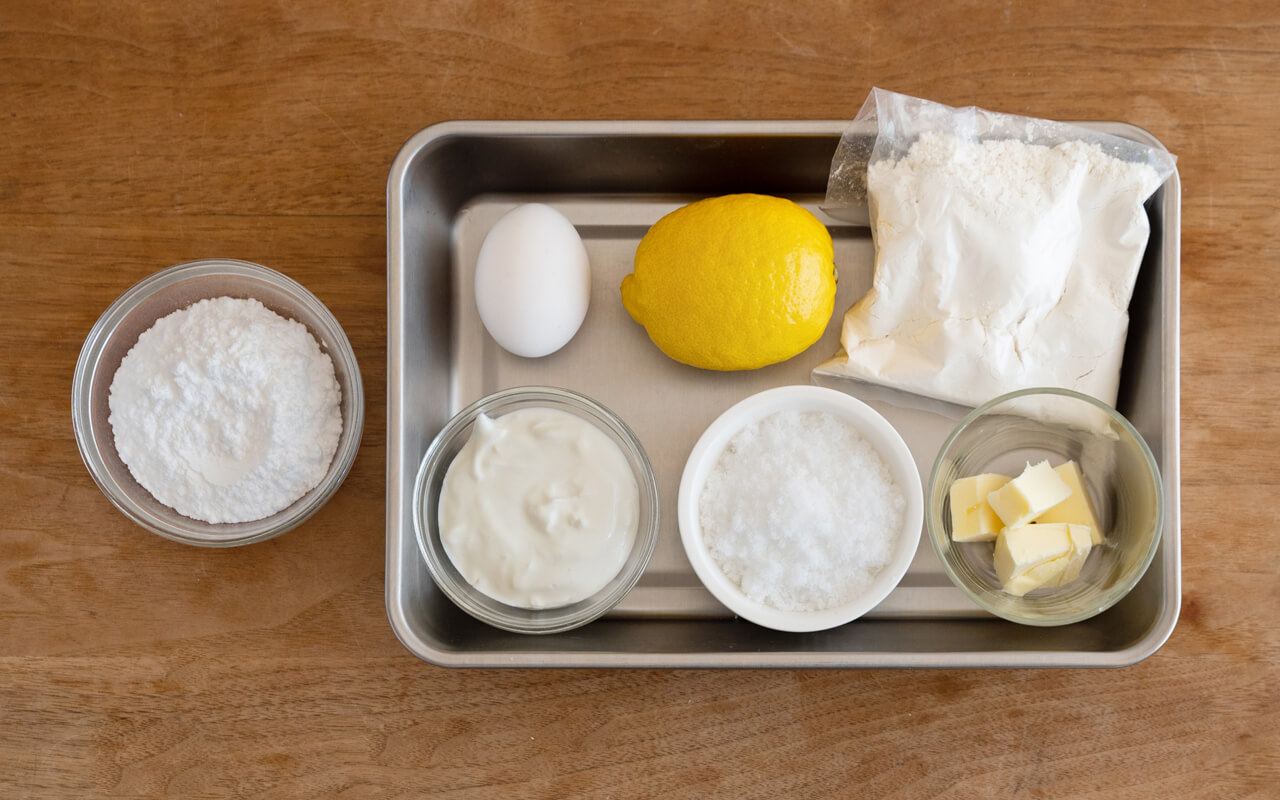ホットケーキミックス　150g　レモンの皮　１個分（飾り用に少量残しておく） レモン果汁　大さじ１と１/2 バター（食塩不使用）　50g ギリシャヨーグルト　大さじ４（水切りヨーグルトでも作れます） 卵　１個 砂糖　50g ＜アイシング＞ 粉砂糖　５０g