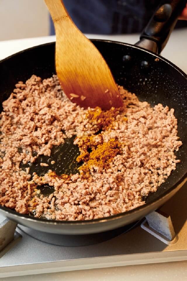写真：フライパンで炒めたひき肉の色が変わり、カレー粉を加えてさらに炒める様子