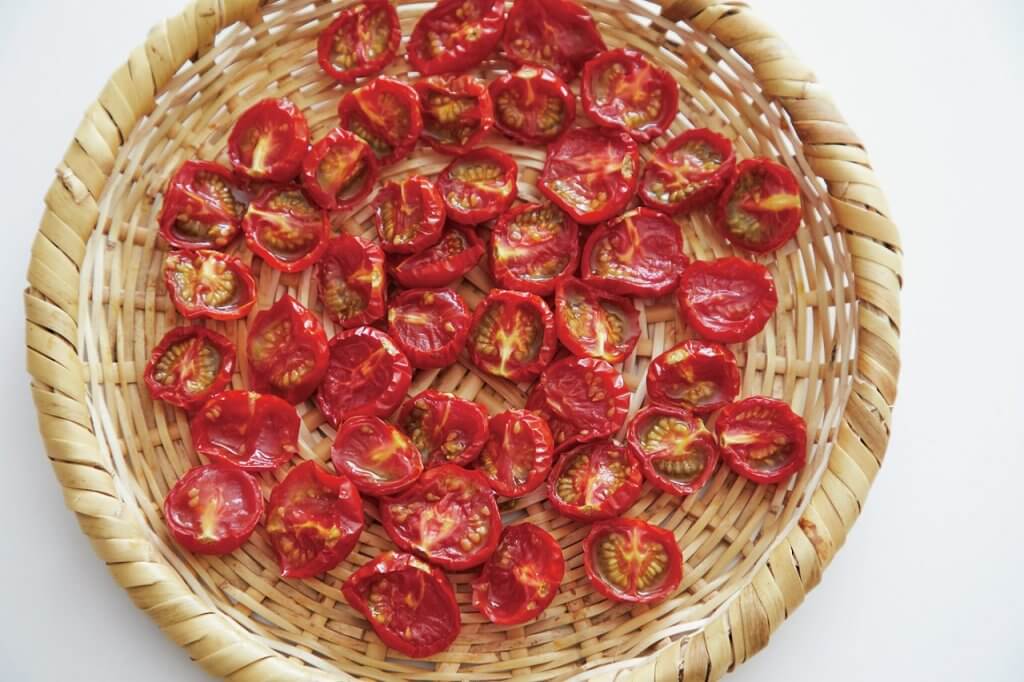 写真：ざるカゴの上でトマトを乾燥させる様子