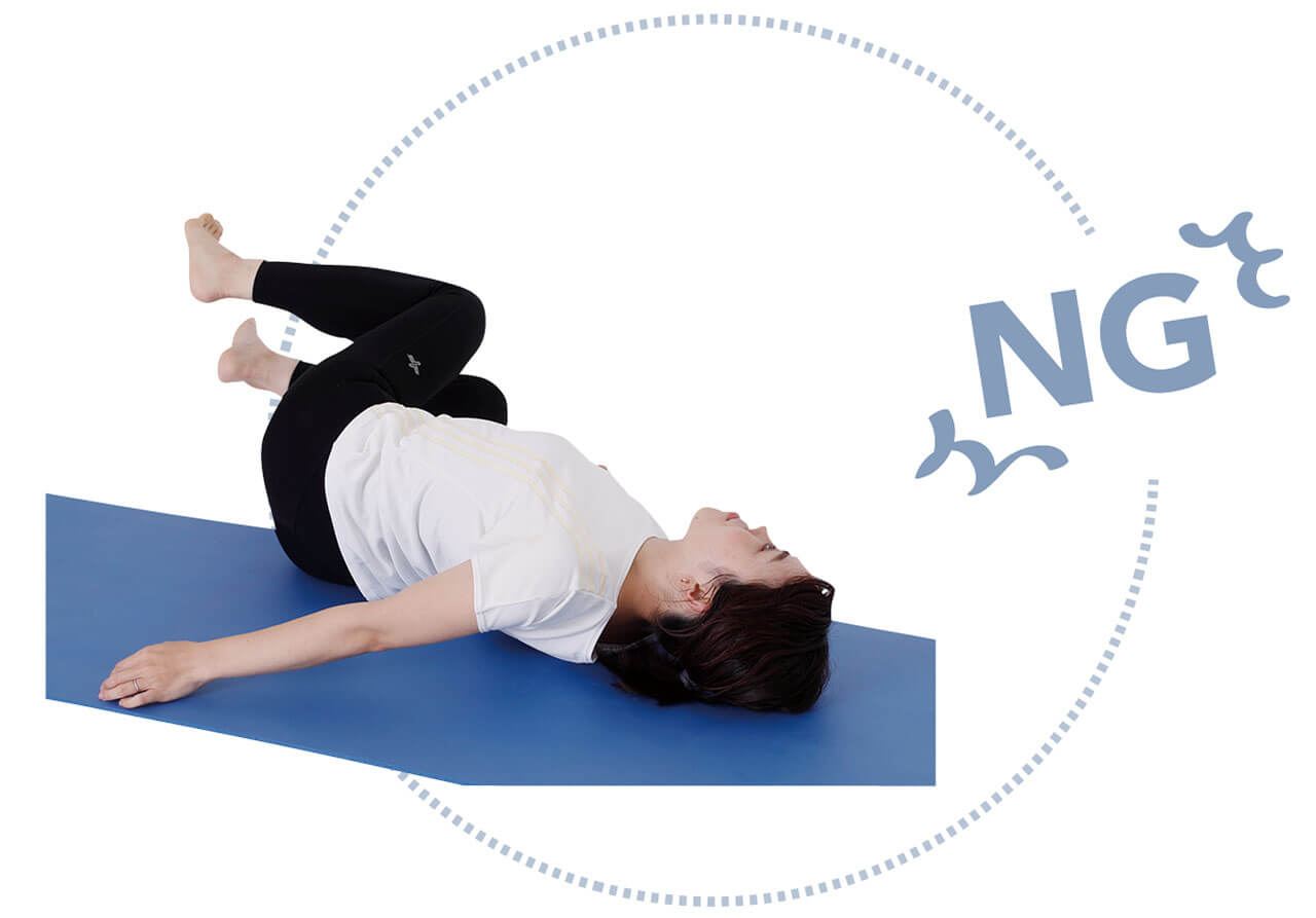 NG　足を倒したら反対側の体が浮いてしまう。肩と背中が床から浮くと、腹筋への効果減。