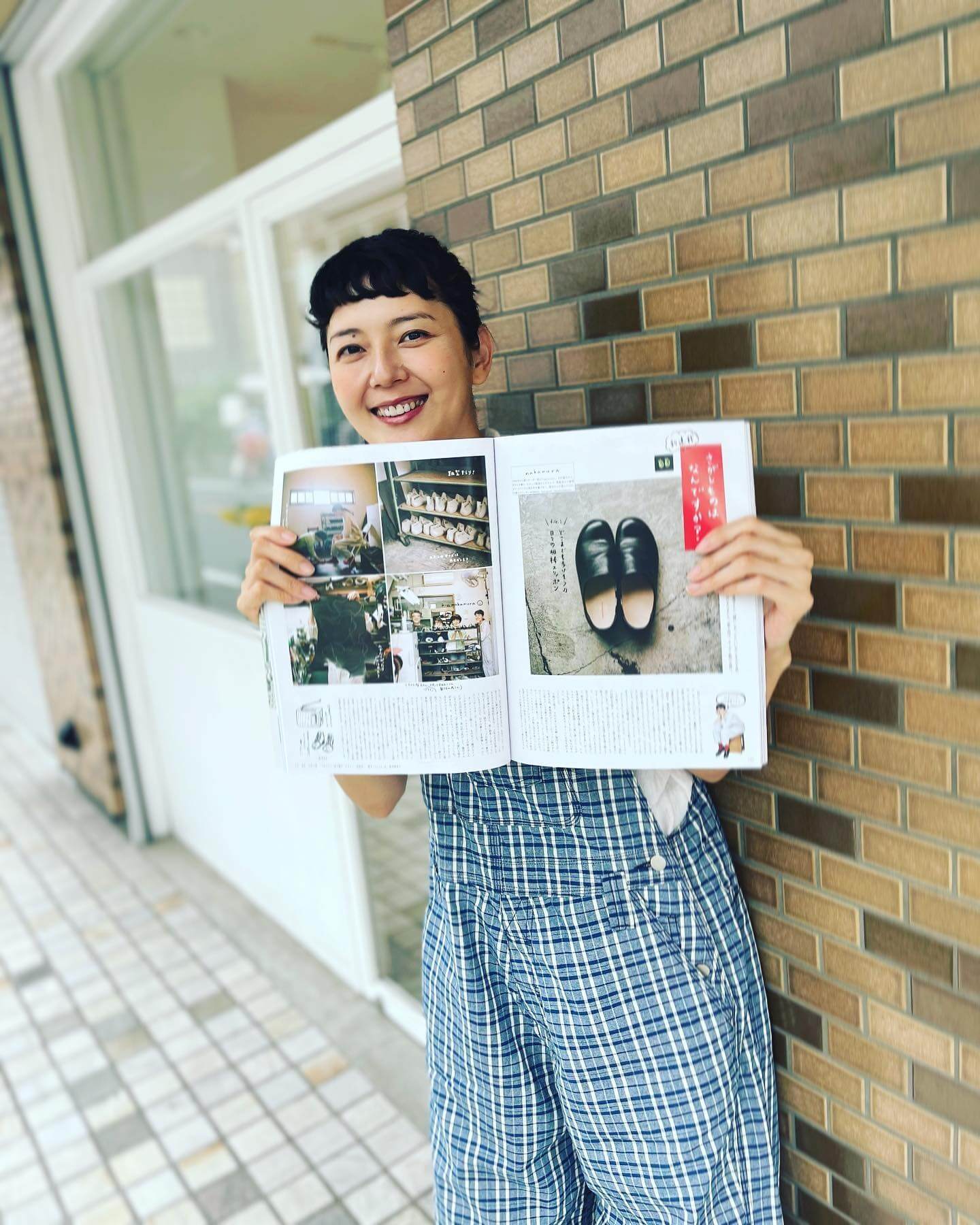 写真：LEE8月号の「さがしものはなんですか？」のページを開いて笑顔でカメラに向く菊池亜希子さん