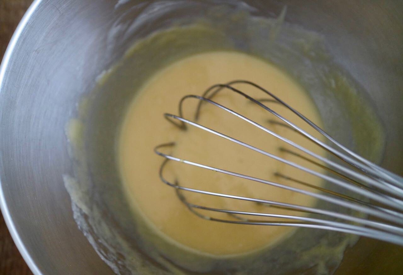卵をときほぐして2回に分けて加え、泡立て器でそのつど混ぜる。