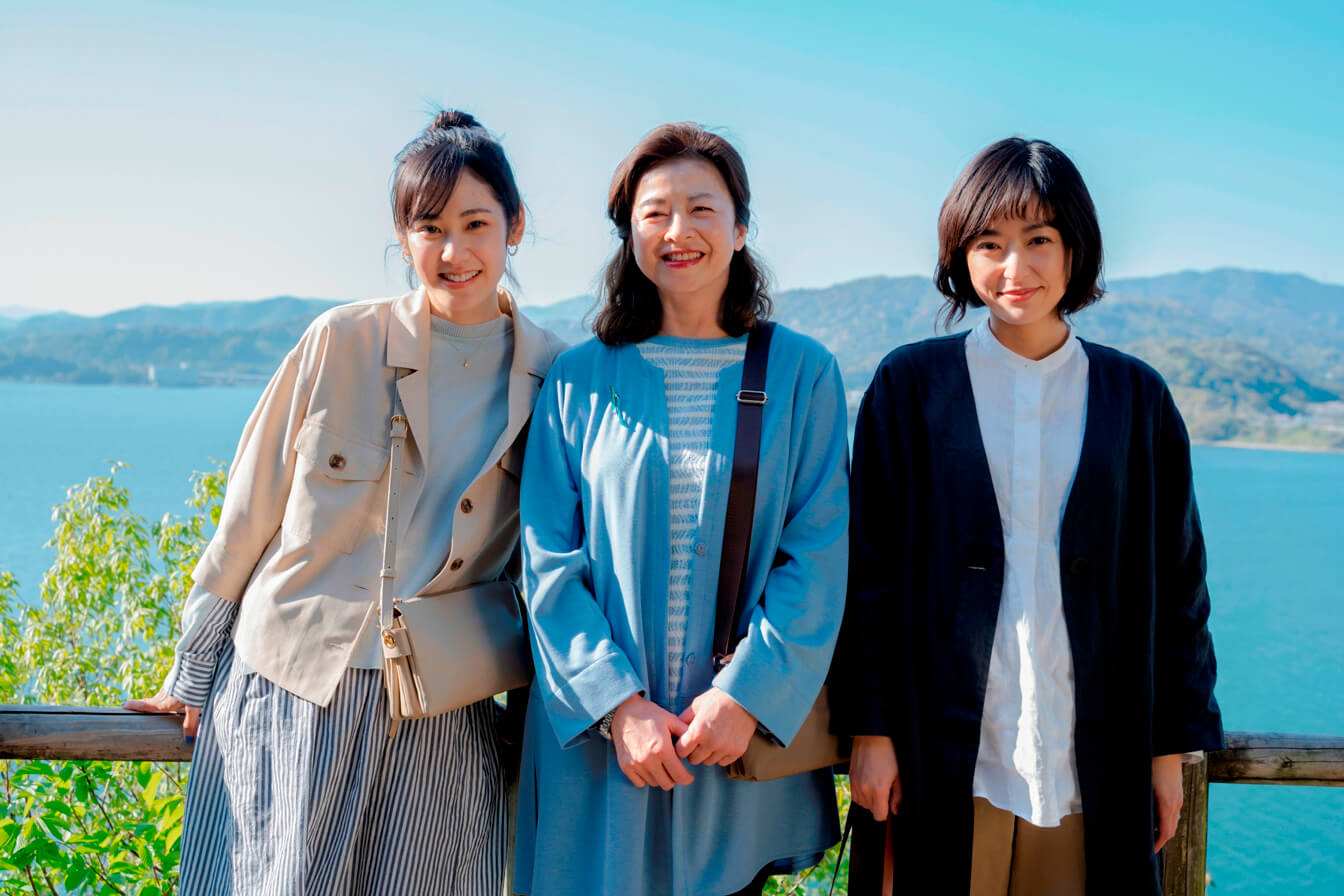写真：映画「わたしのお母さん」のワンシーン/井上真央さんと母役の石田えりさんと若い女性3人が立ち並び記念撮影をするような様子