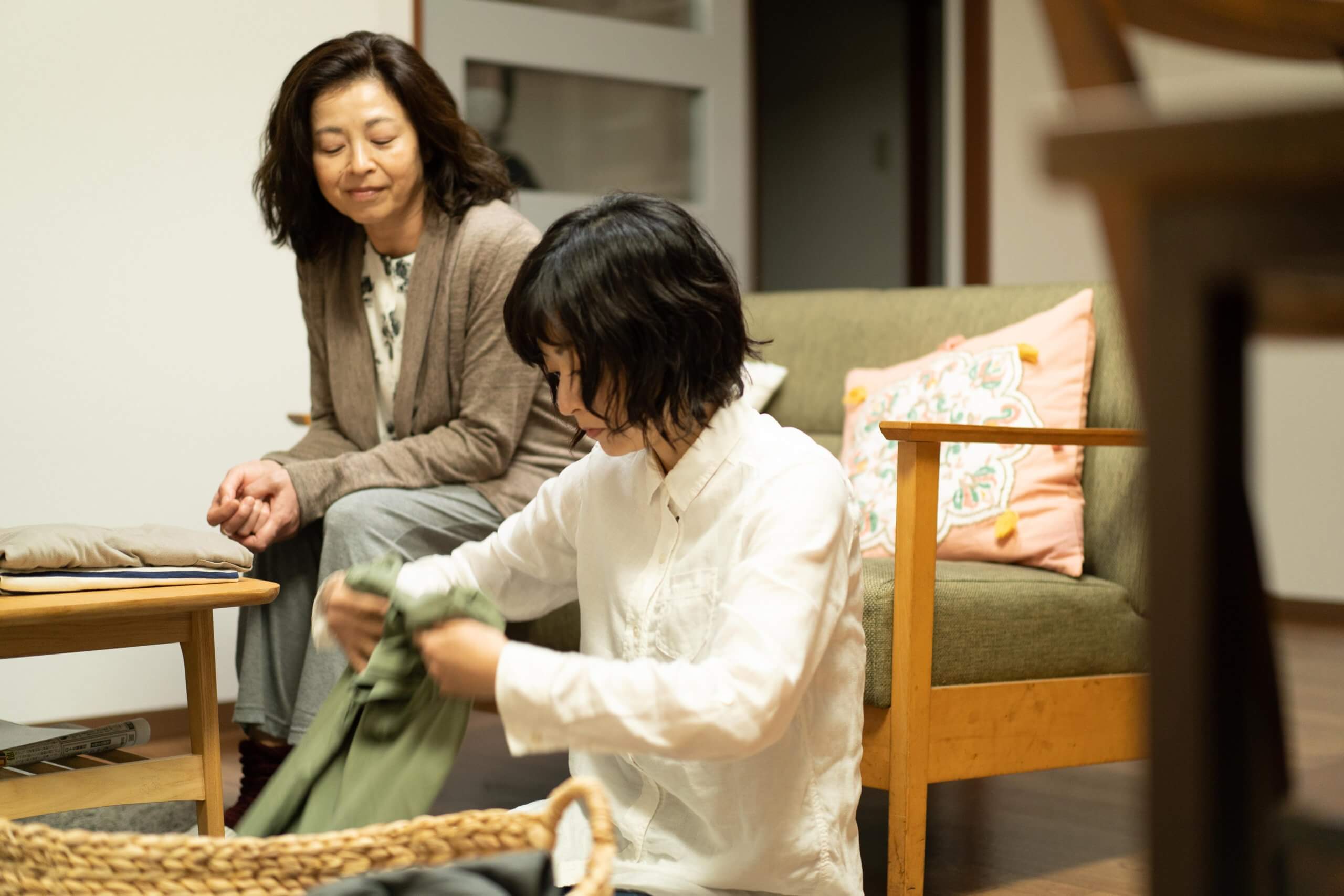 写真：映画「わたしのお母さん」のワンシーン/洗濯物をたたむ井上真央さんと、それをソファに座ってみている母役の石田えりさん