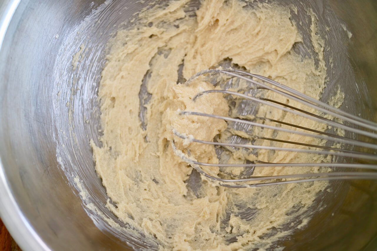 ボウルにバターを入れ、泡立て器で空気を含ませるようにクリーム状になるまで練り混ぜる。