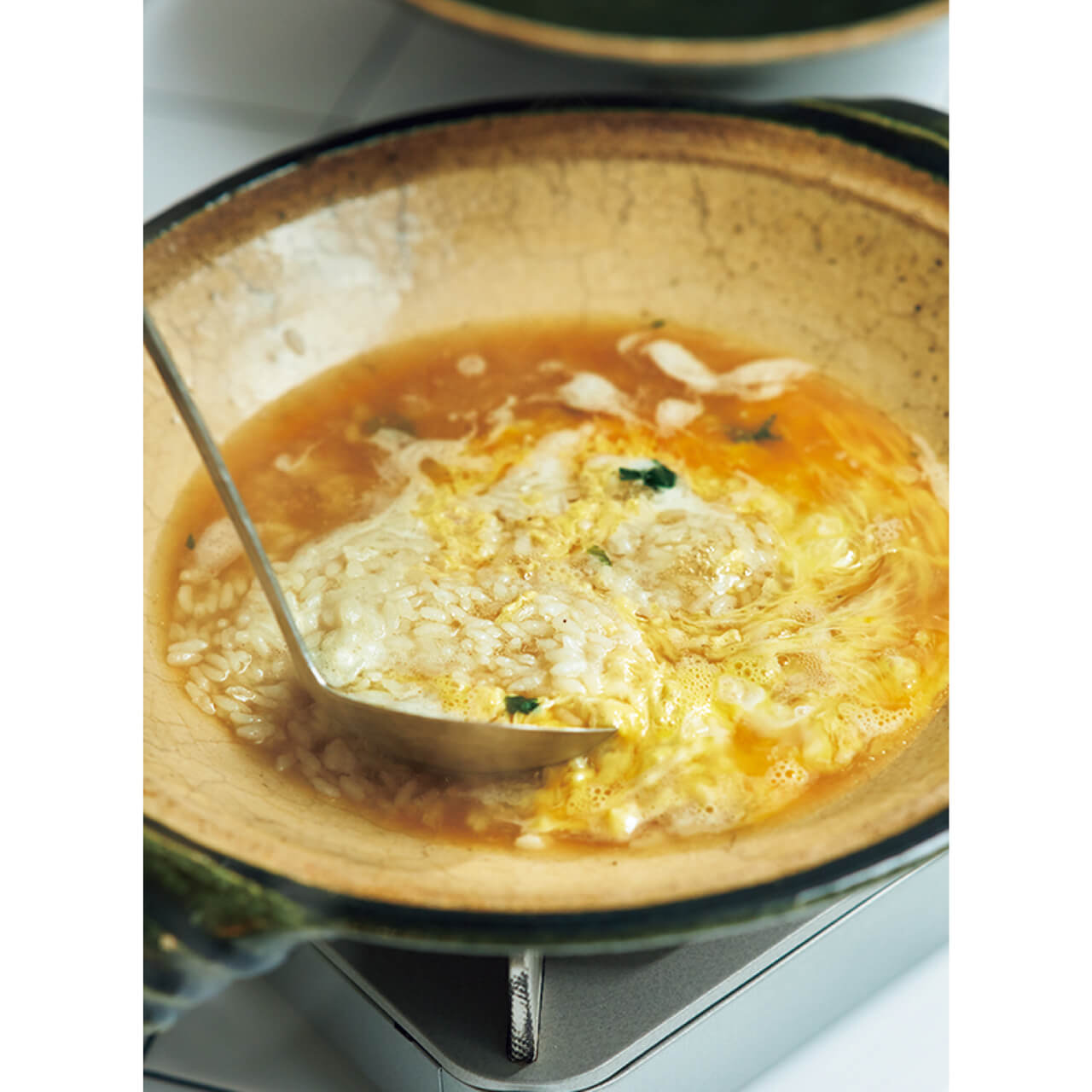 残ったスープにごはんを入れ、軽く煮る。十分温まったら、全体に溶き卵を流し入れる。「卵の火の通し加減は好き好きなのですが、私はしっかりと火を入れるほうが好みです。スープに残る、春菊の香りを味わって」（ウー・ウェンさん）