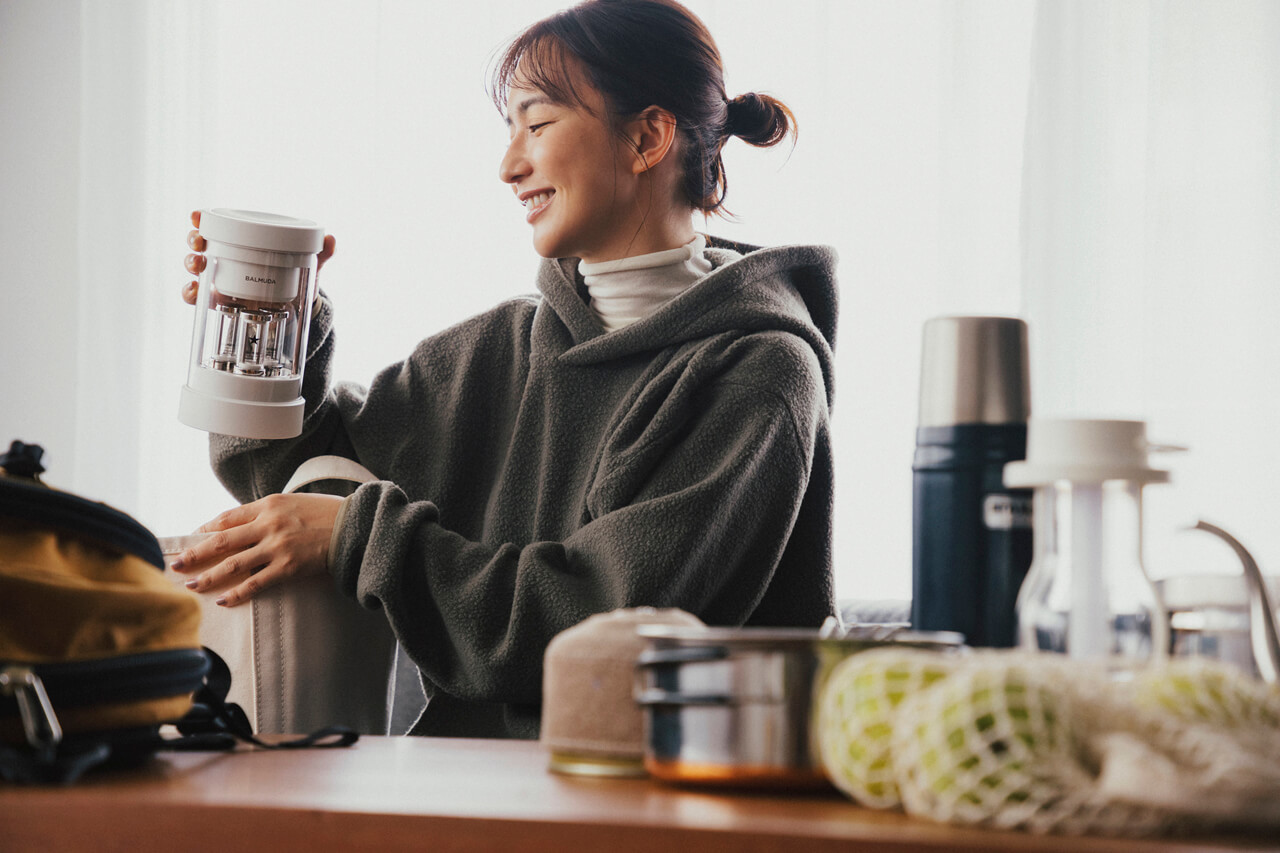 キャンプの持ち物としてバルミューダ ザ・スピーカーを手に取る優木まおみさん