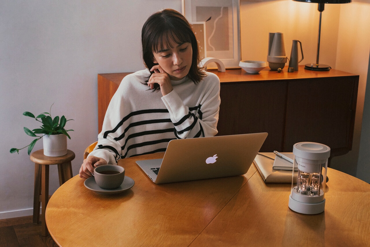 PCで作業をしながらバルミューダ ザ・スピーカーで音楽を流す優木まおみさん