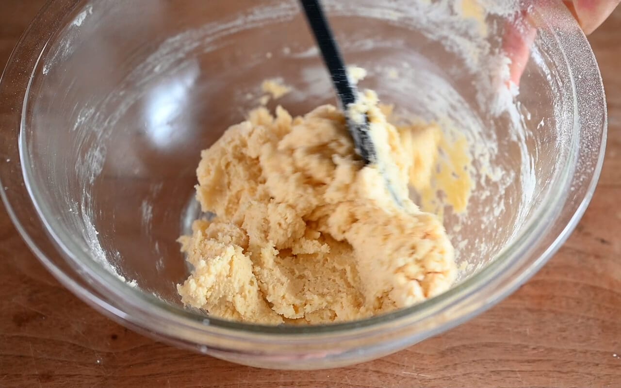 薄力粉と粉チーズをふるって加え、ヘラで混ぜまとまめる。