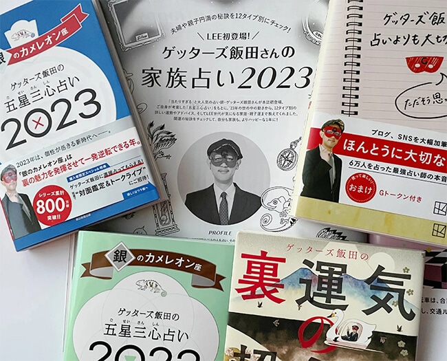 写真：LEE1・2月合併号「ゲッターズ飯田さんの家族占い2023」のページとゲッターズさんの著書の数々