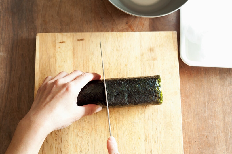 写真：ワタナベマキさんの巻き寿司の切り方1＿巻きずしの中央を切る