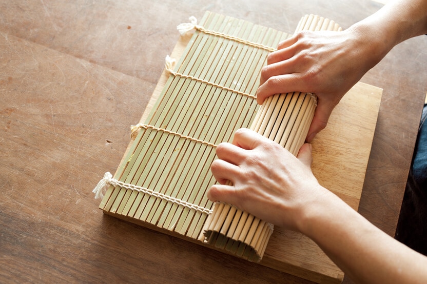 写真：ワタナベマキさんの巻き寿司の巻き方4-1＿巻き簾で寿司全体を包み形を整えているところ