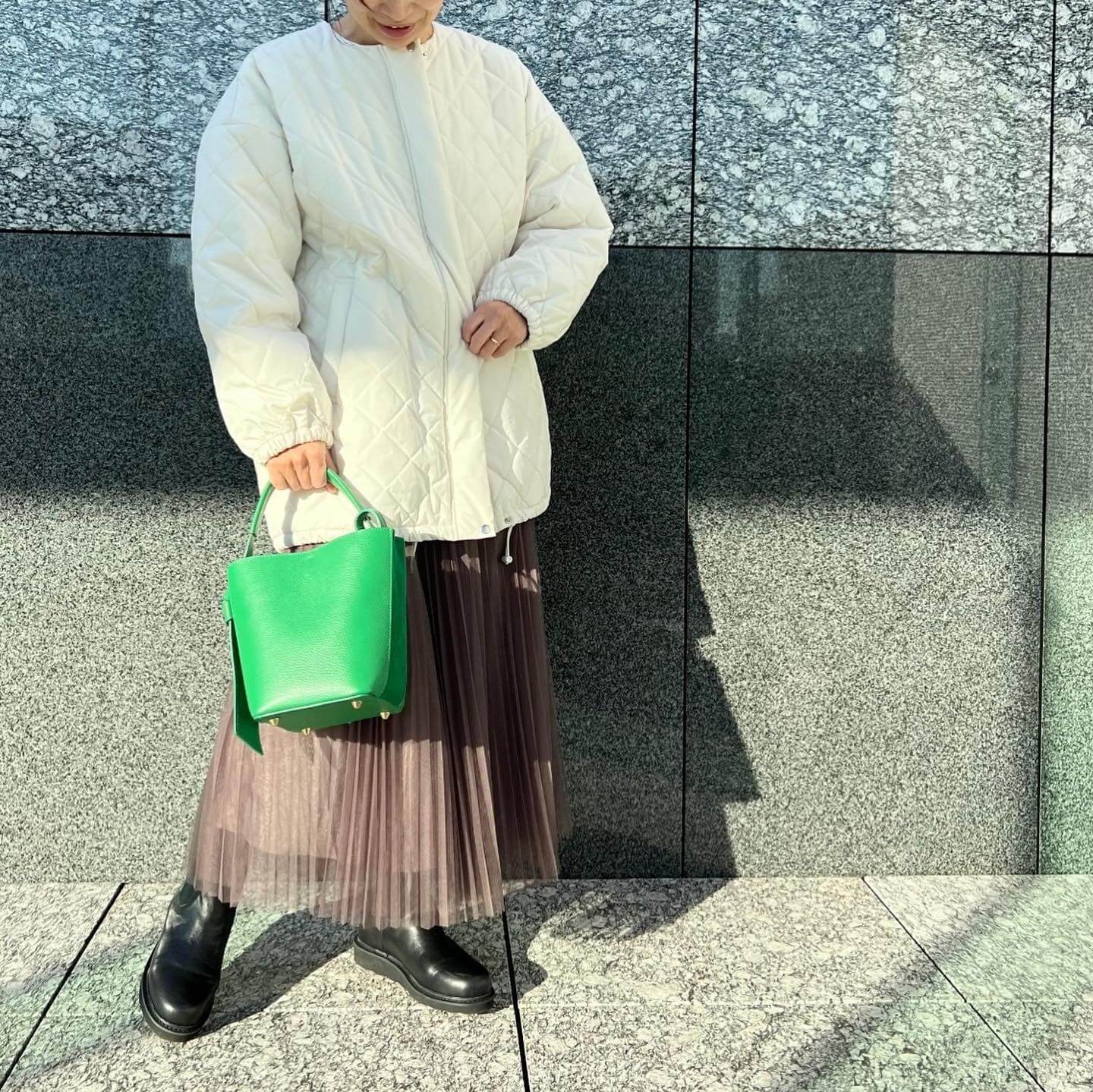 写真：キルティング中綿コートとチュールプリーツスカートを着たLEEマルシェスタッフ（正面からのアングル）