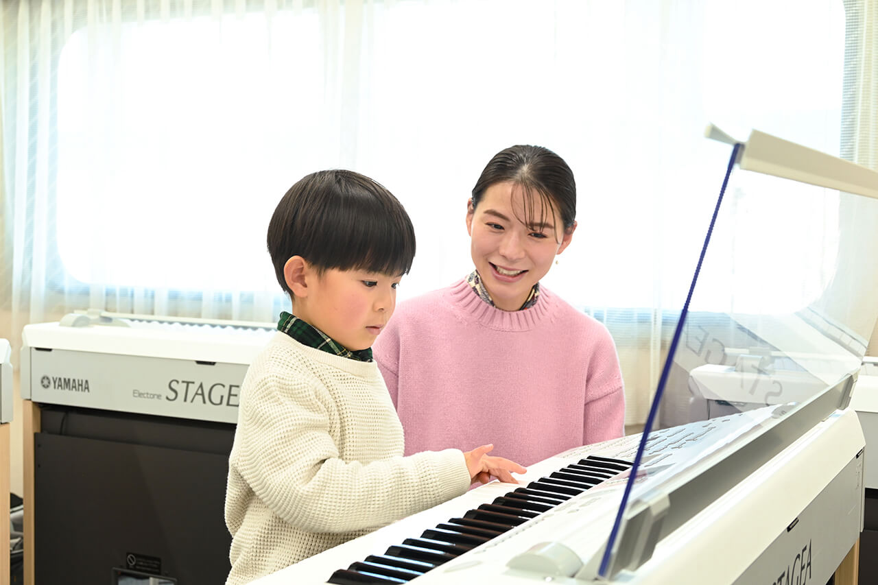 ピアノを弾く山口蒼人くんと見守る山口友香さん
