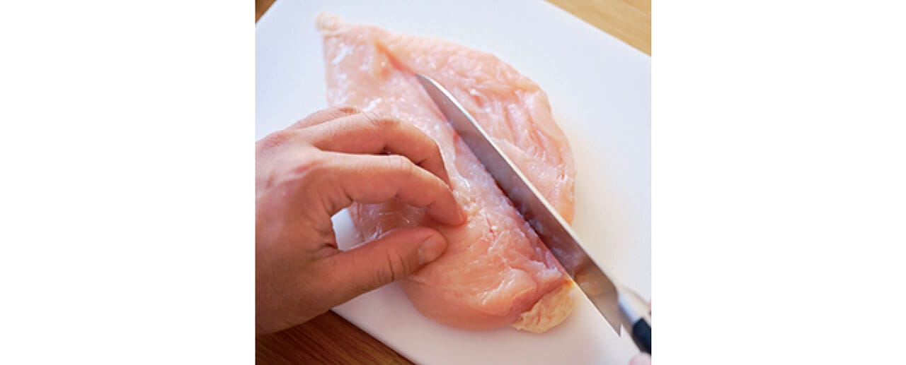 鶏むね肉の観音開きの方法。身が厚いほうを下になるよう縦に置き、中央に軽く切り目を入れる