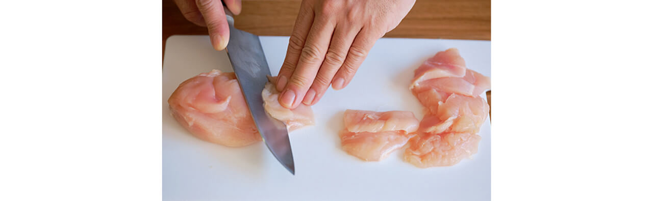 そぎ切りは左手で押さえながら、包丁を斜めに引く。肉の繊維を断つのでやわらかくなる