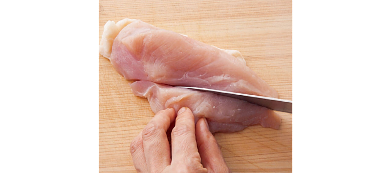 肉を横長に半分に切る。縦に入ったすじを、横に断ち切るように包丁を入れるとやわらかな食感に