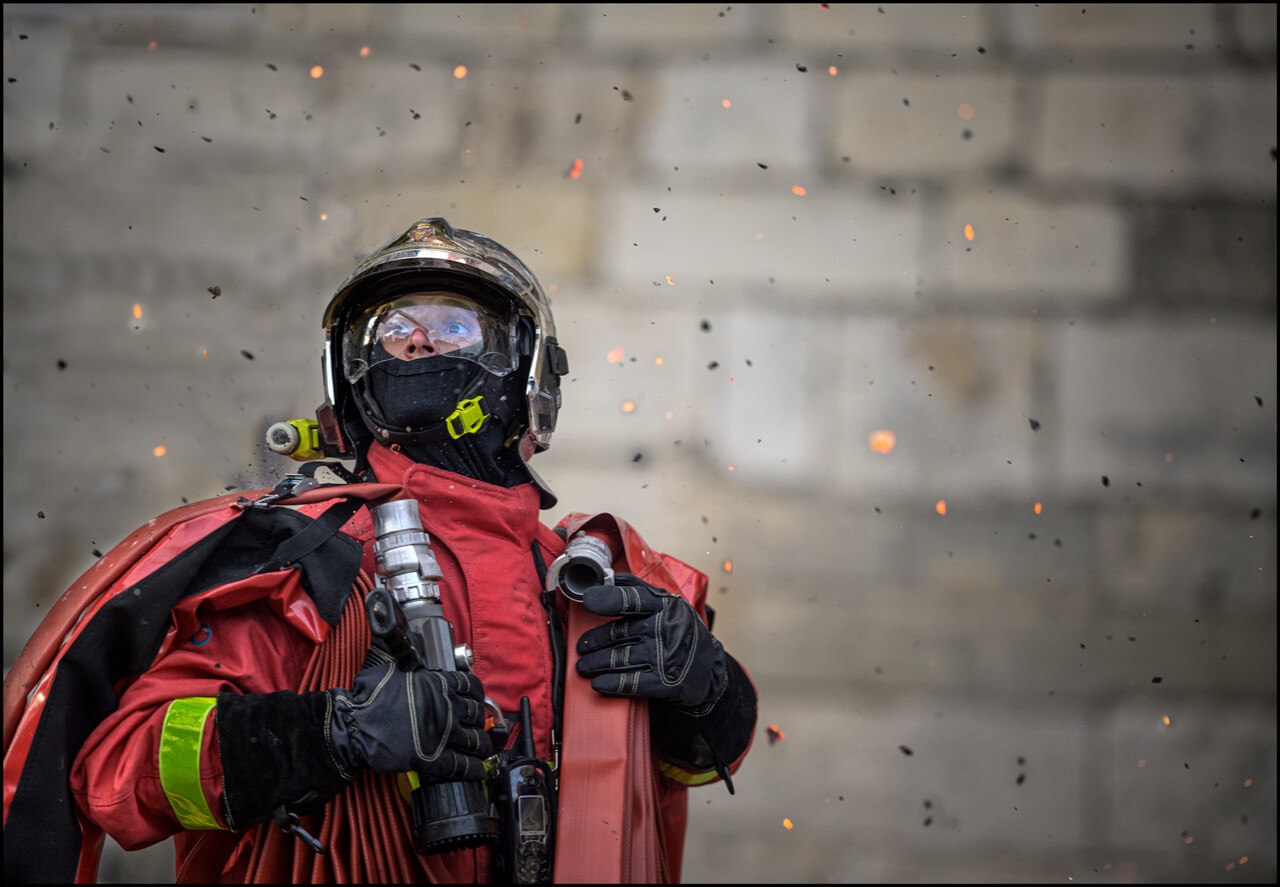 写真：火の粉が降る中たたずむ消防士