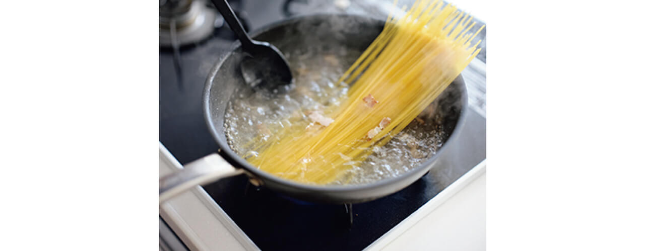 ②にＡを加えて沸騰させ、スパゲッティを入れて湯から出ている部分に湯を回しかけて湯の中に沈める。中火で袋の表示時間どおりに加熱する。