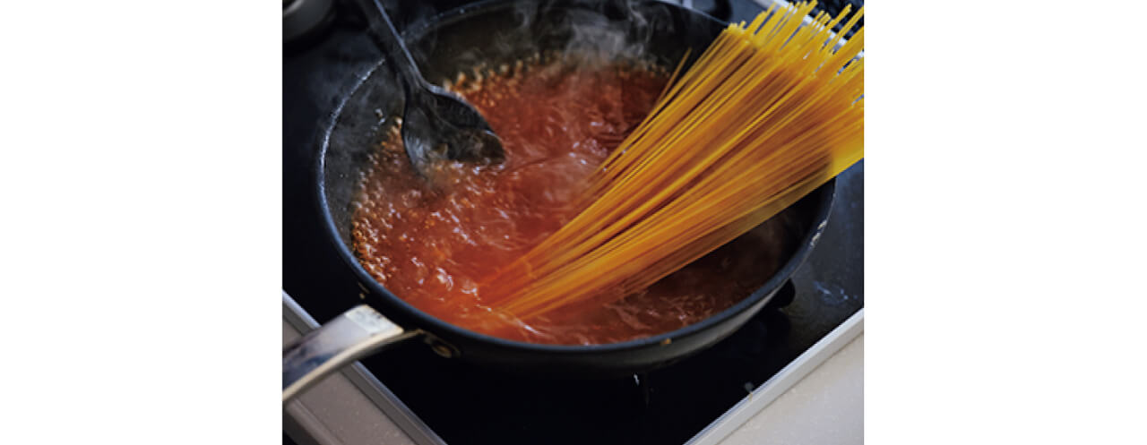 フライパンにトマトケチャップの半量を入れて中火にかけ、⾹りを⽴てる。Ａを加えて沸騰させ、スパゲッティを加える。湯から出ている部分に湯を回しかけて湯の中に沈め、中火で袋の表示時間どおりに加熱する。