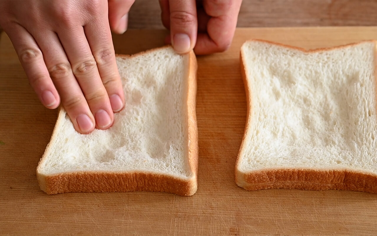食パンの中央を指で押すようにしてくぼませ