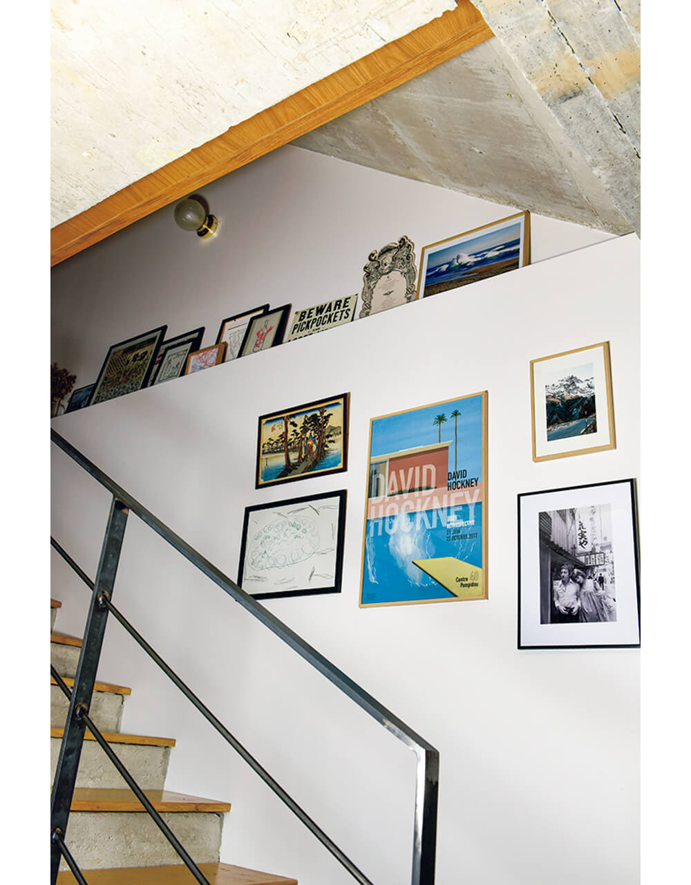 写真やポスターが飾られた階段の壁