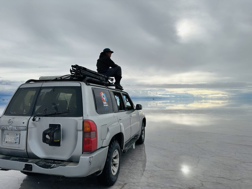 ウユニ塩湖で4WDの上に乗る息子