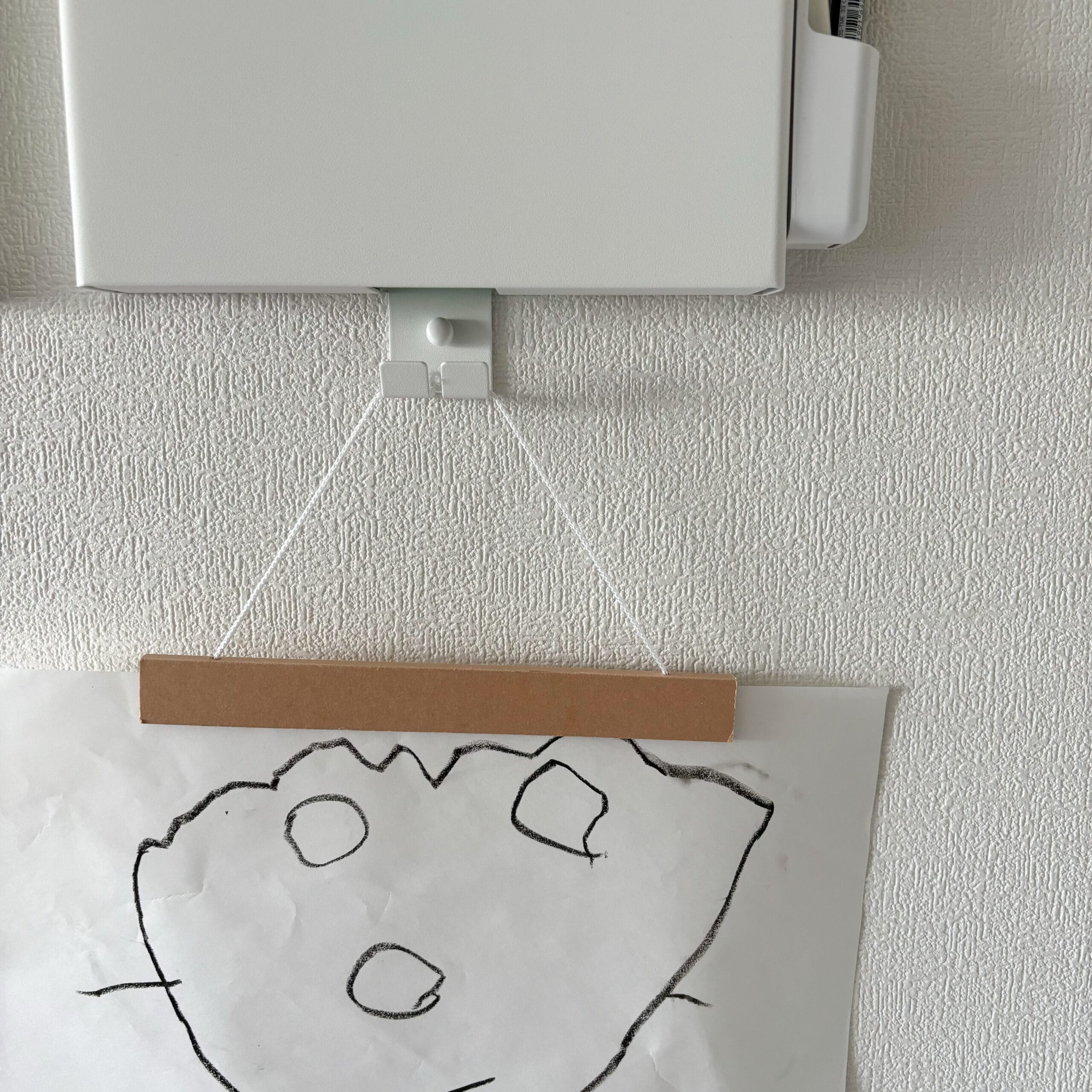 子どもの絵をぶらさげた石こうボード壁対応プリント収納ホルダー