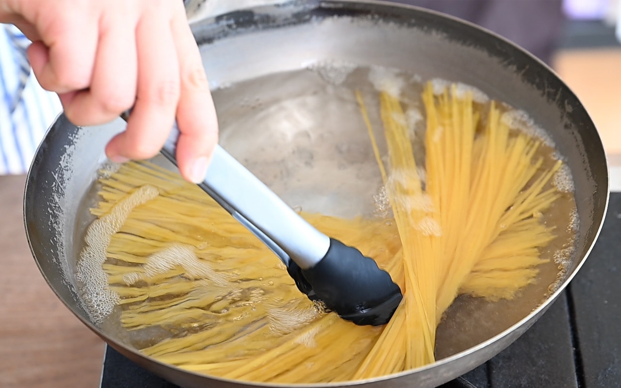 沸いたお湯２L程度に塩大さじ１（分量外）を入れ、スパゲッティを入れて混ぜ、表示時間どおりに茹でる。