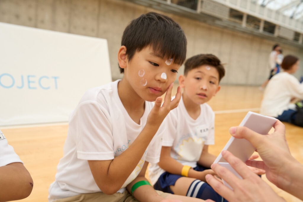 アネッサ　キッズイベント 日焼け止めの塗り方を教わる子どもたち　