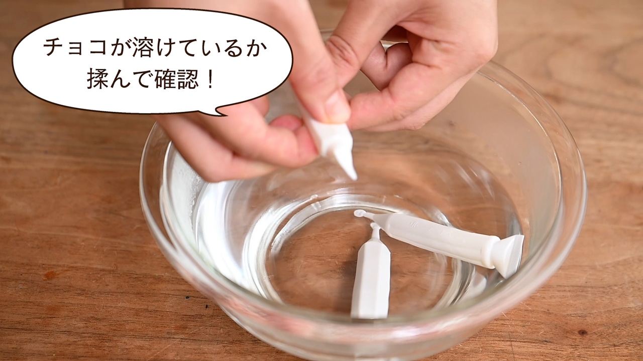 チョコペンを50℃のお湯に入れて溶かす。