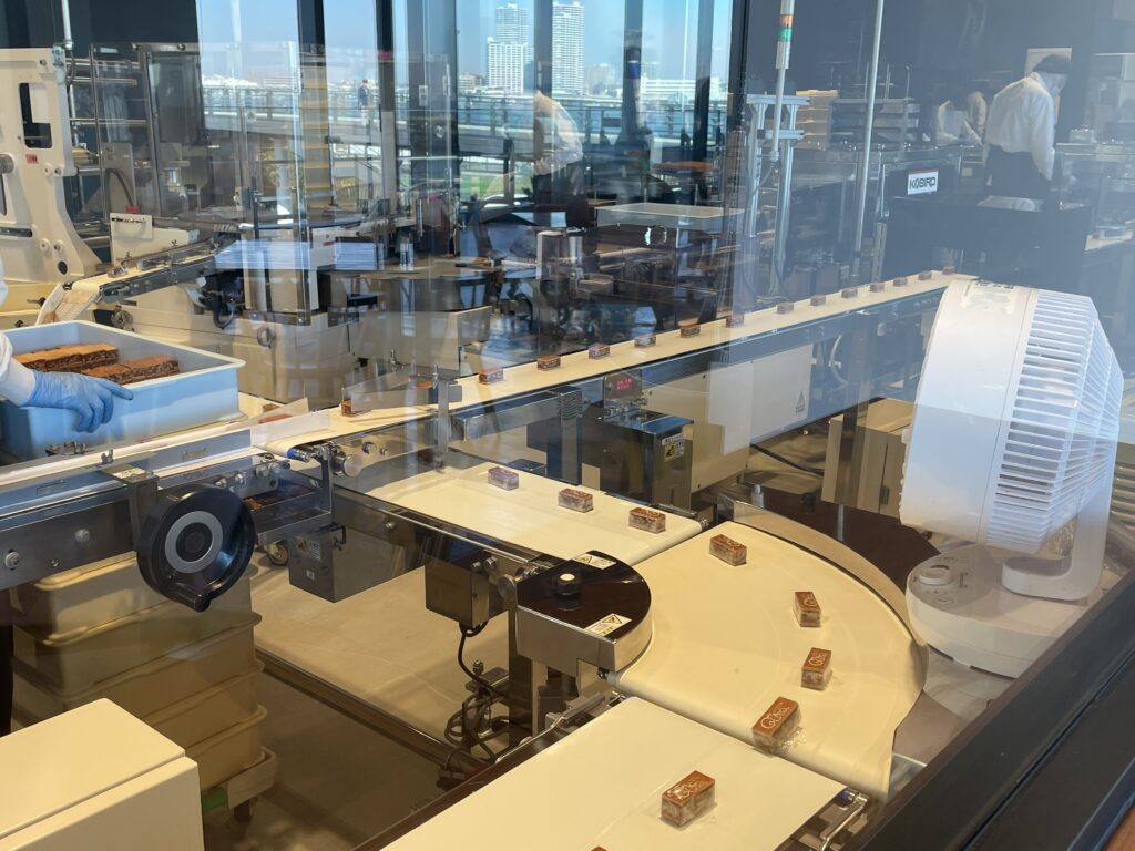 カットされたクルミッ子がベルトコンベアで運ばれる様子