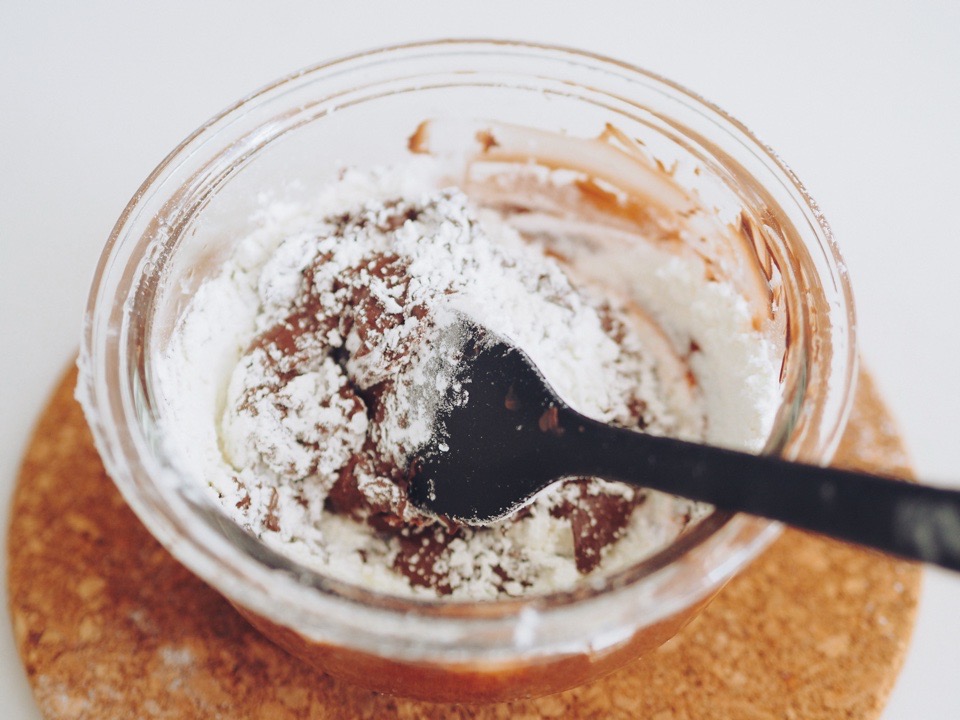 透明のボウルに入った溶けたチョコレートに薄力粉を混ぜたところ