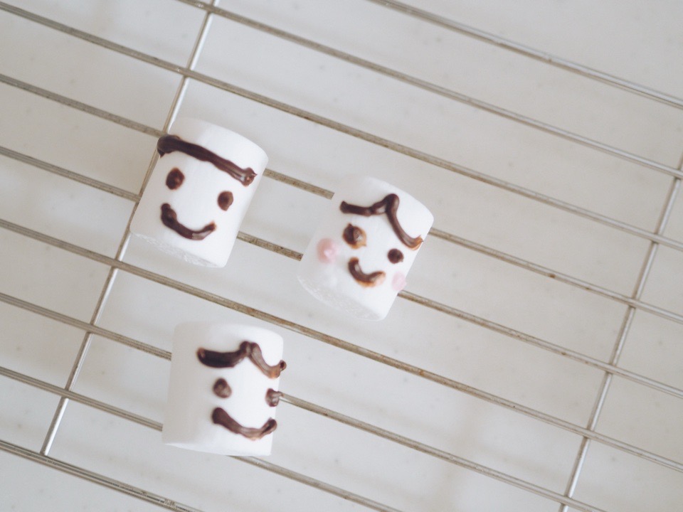 マシュマにチョコペンで顔を描いたものが3つ網の上にある